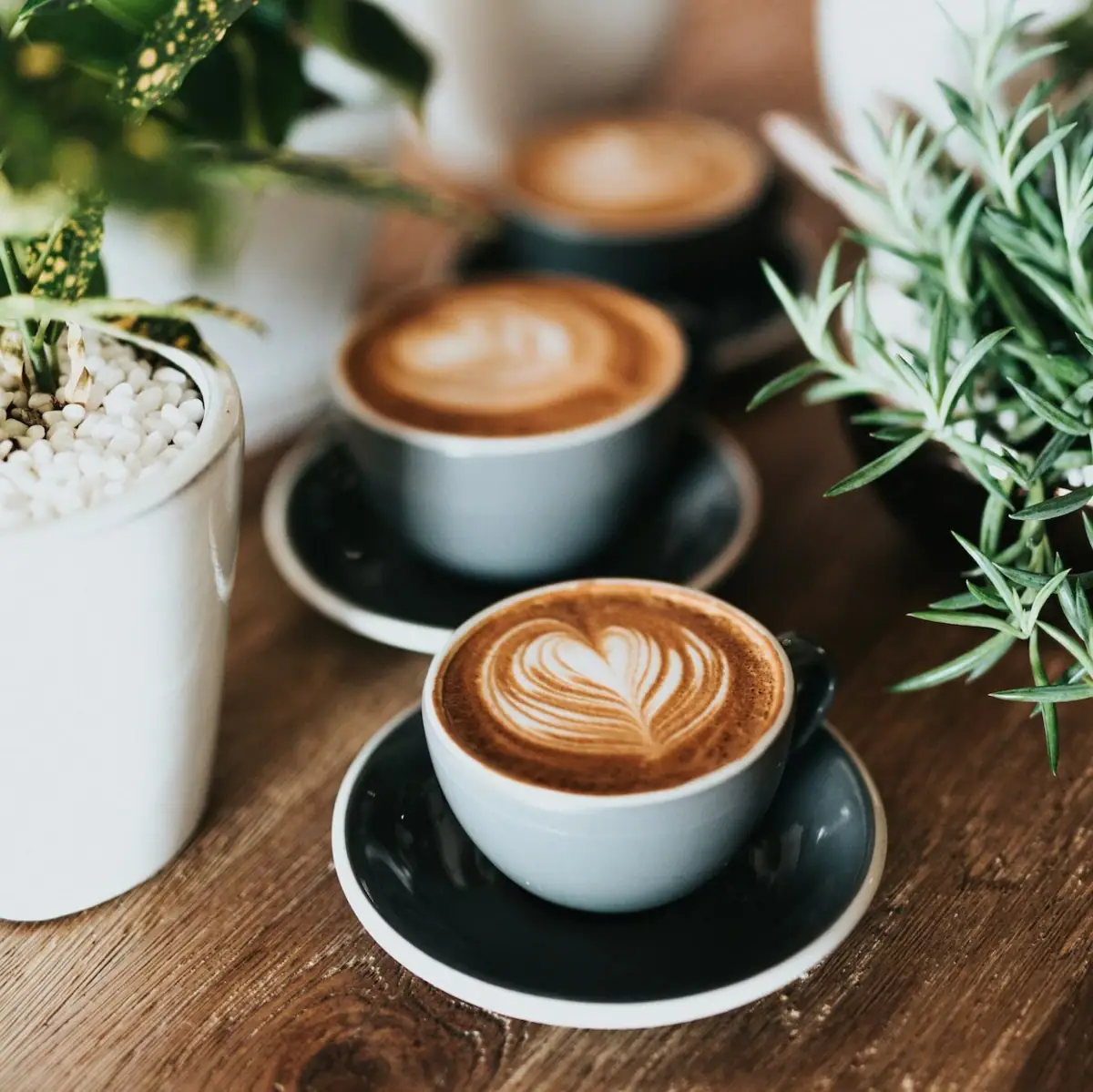 Eine Gruppe von Kaffeetassen mit herzförmigem Milchschaum.