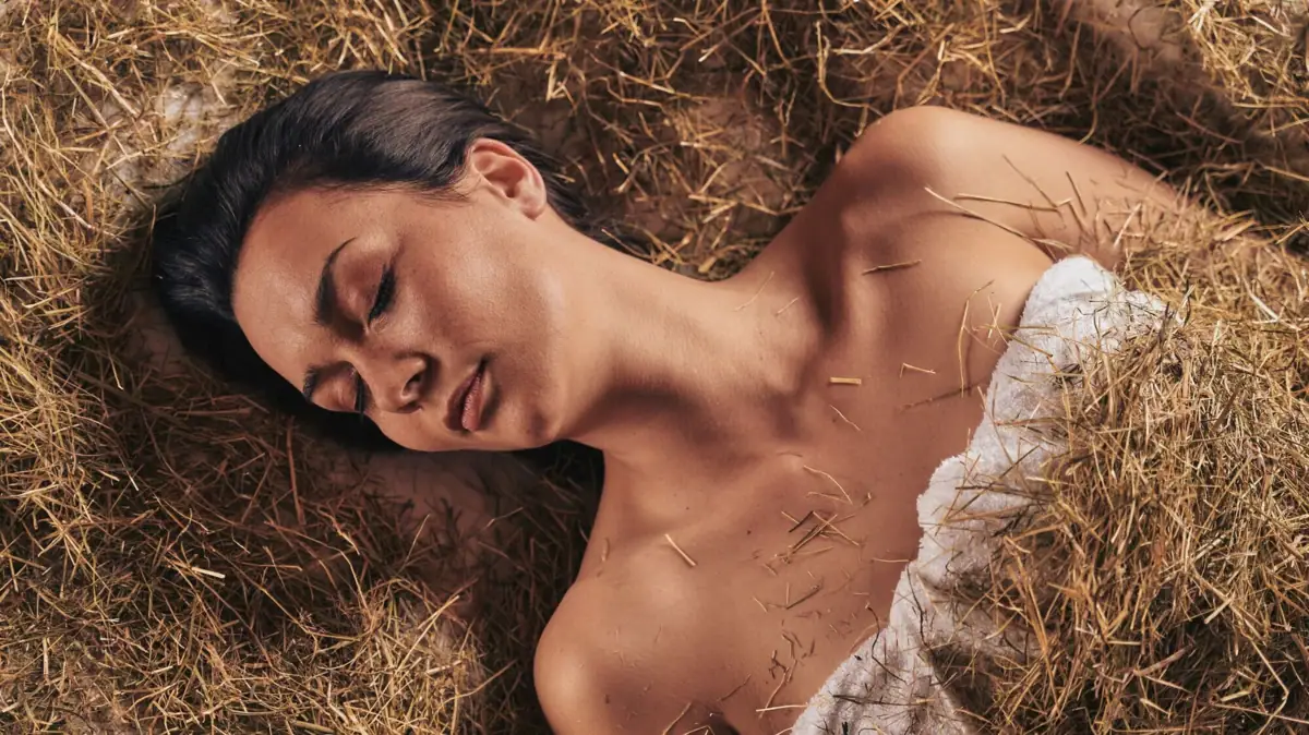 Wellness im Gothischen Haus Frau liegt im Heubett während einer Anwendung