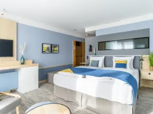 Ein Hotelzimmer mit einem großen Bett und einem Schreibtisch.