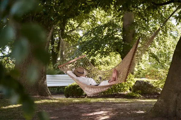Eine Person liegt in einer Hängematte im Freien.