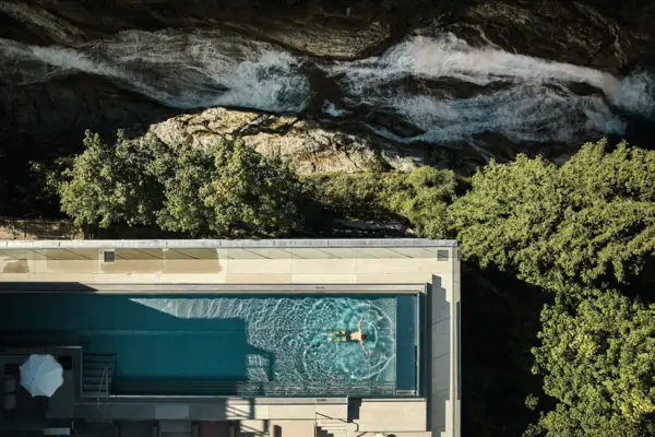 Person schwimmt in einem Pool im Freien.