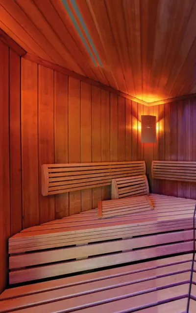 Holzsauna mit warmem orangefarbenen Licht. 