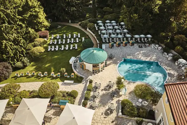 Ein Swimmingpool mit Liegestühlen in einem Park.