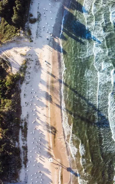 Strand mit Wellen und Sand aus der Vogelperspektive