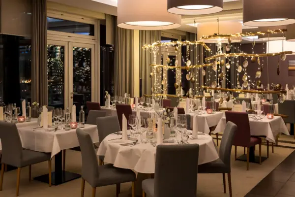 Ein Raum im A-ROSA Hotel mit Tischen und Stühlen, eingerichtet für Silvester auf Sylt.