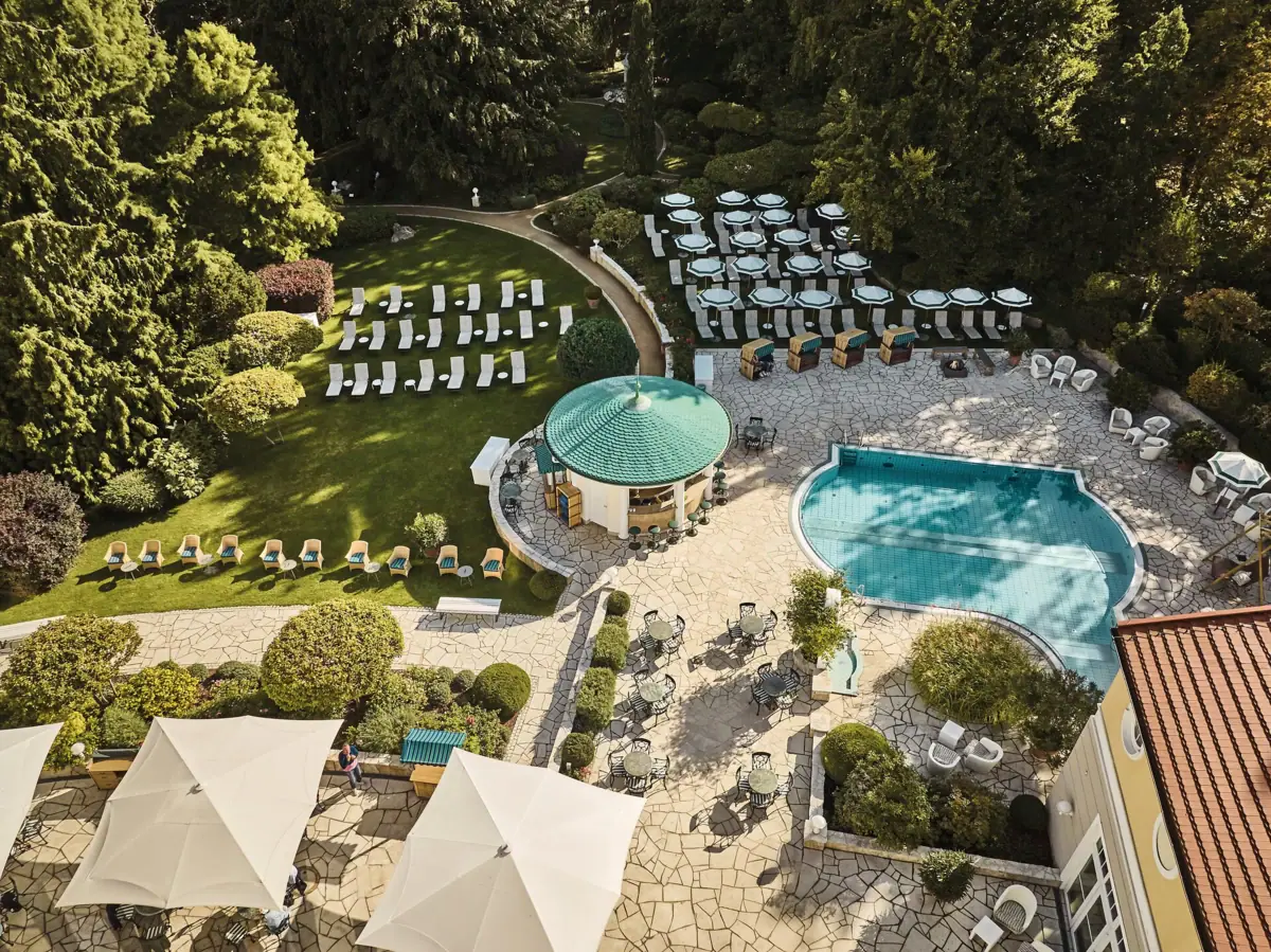 Ein Swimmingpool mit Liegestühlen im Garten vom SPA-ROSA Heringsdorf.