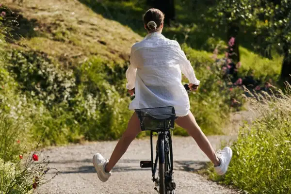 Eine Frau fährt auf einem Weg Fahrrad.