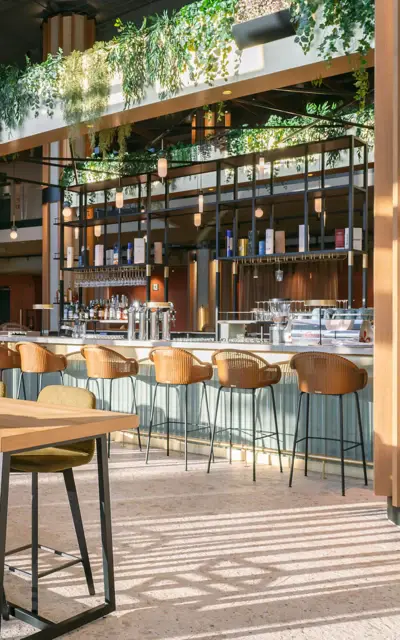 Ein Raum mit Tischen und Stühlen, wahrscheinlich in einem Restaurant oder einer Cafeteria.