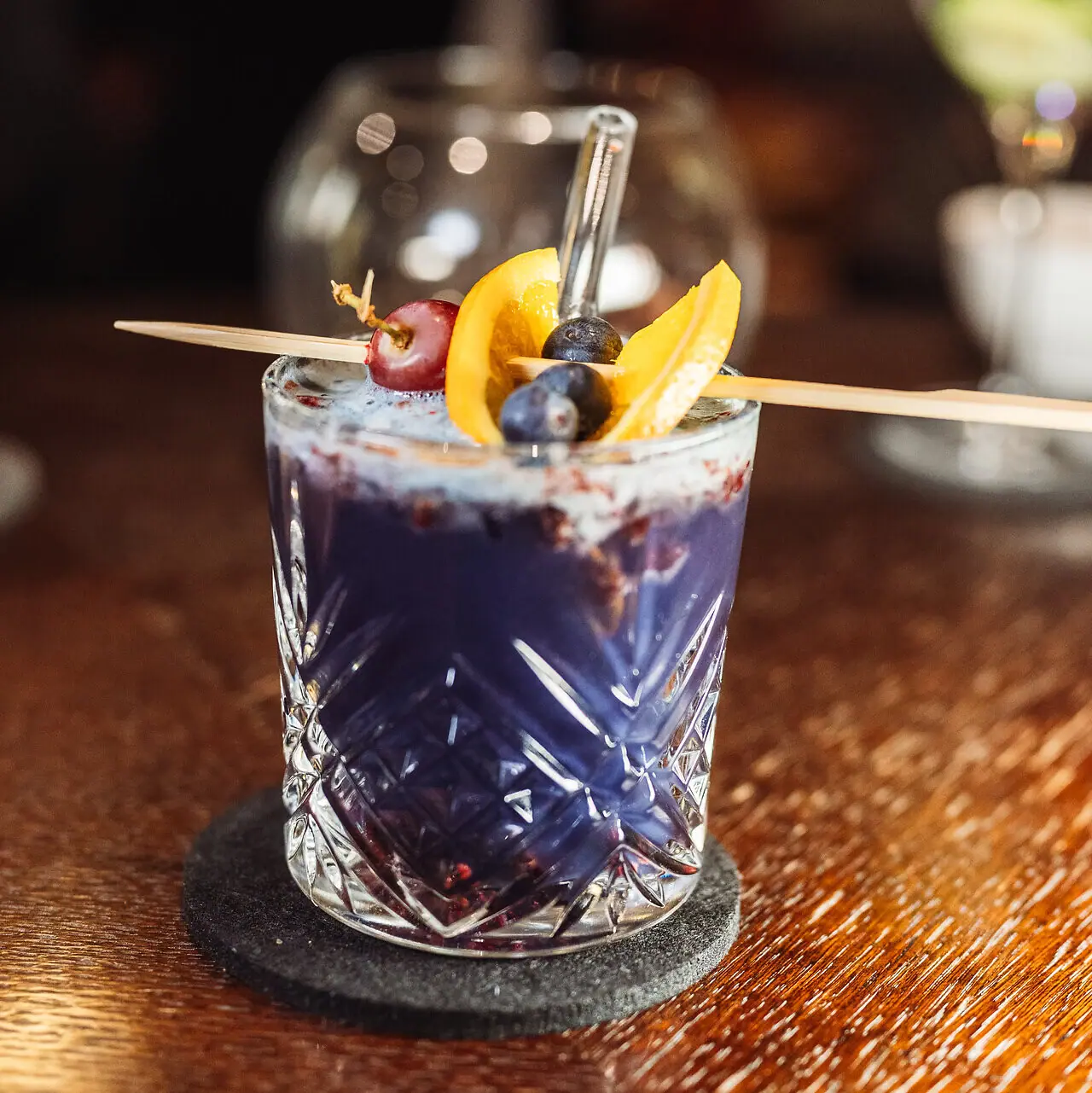 Ein Glas mit einem Getränk und einer Fruchtgarnitur.