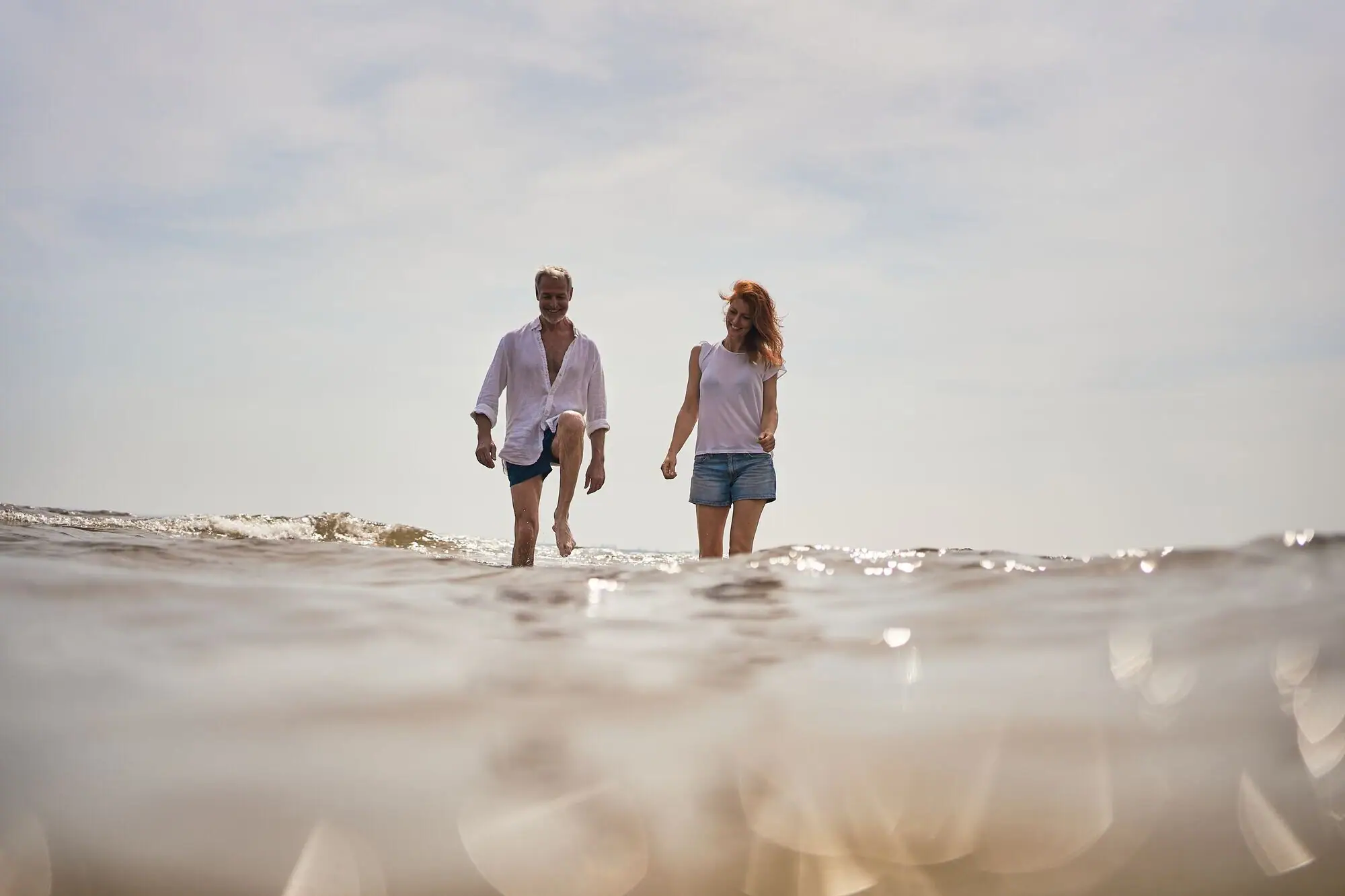 Ein Mann und eine Frau gehen im Wasser spazieren.