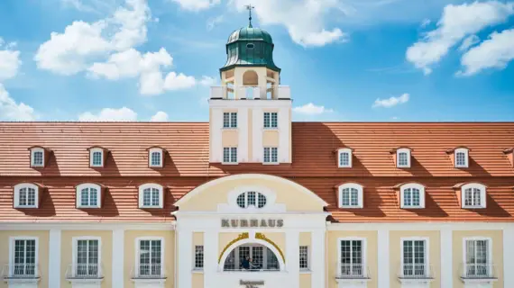 Ein Gebäude mit Glockenturm und Fenstern vor blauem Himmel.