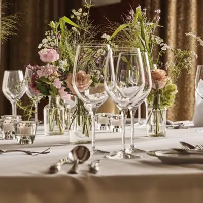 Ein Tisch mit Blumen und Kerzen dekoriert.
