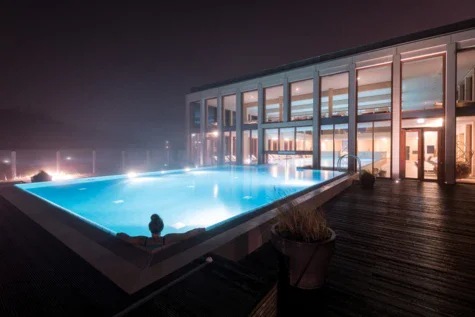 Donna in una piscina termale all'aperto di notte.