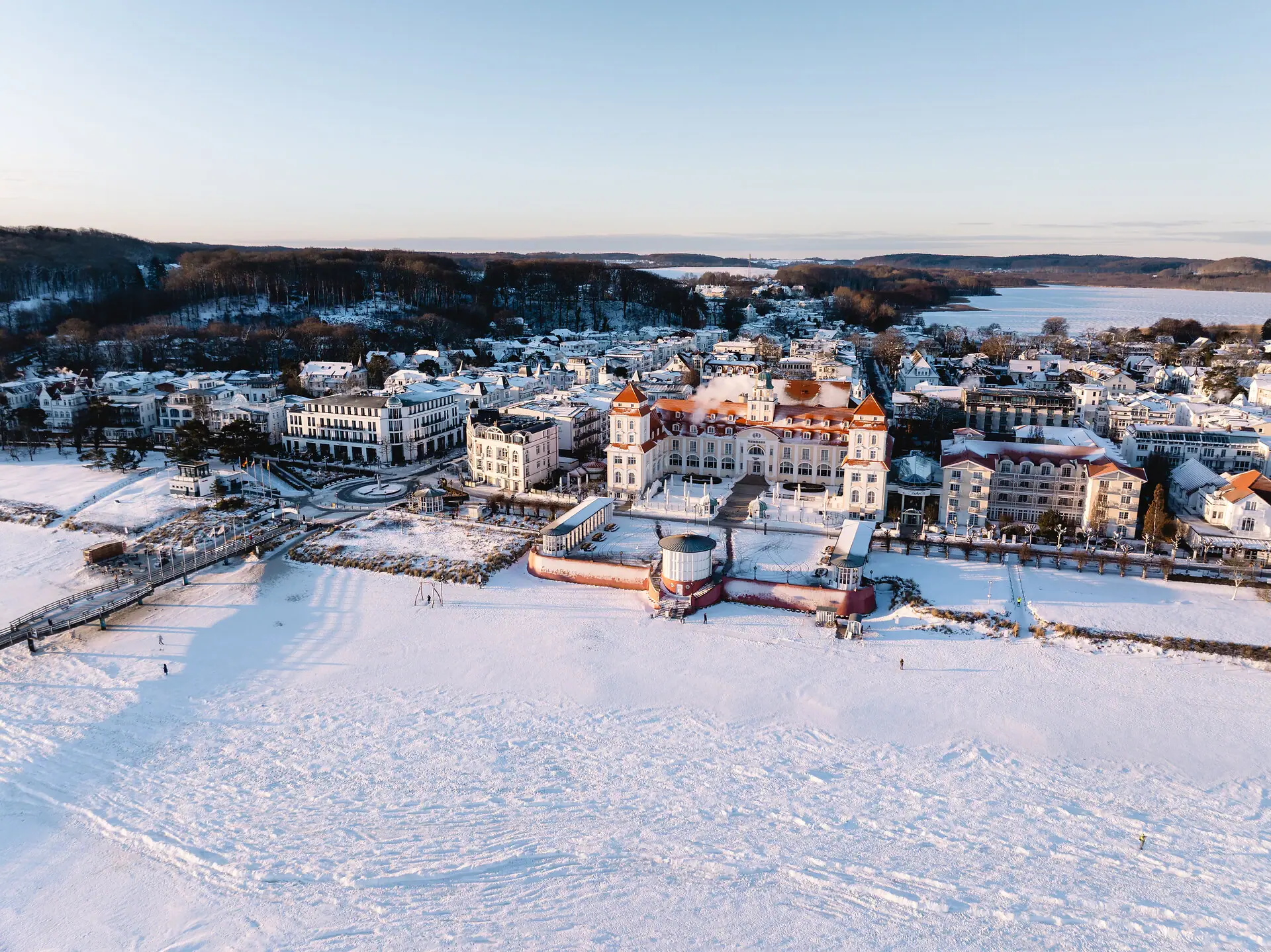 Kurhaus Binz Schneebedeckte Stadt mit Gebäuden und einem Gewässer im Winter.