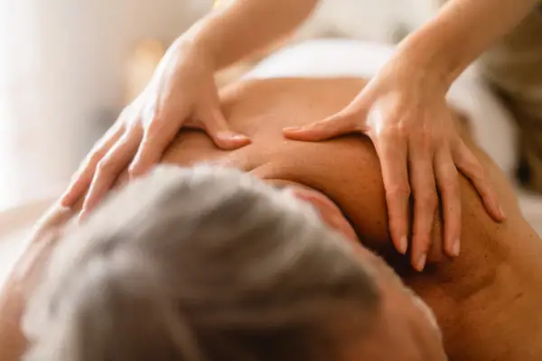 Gothische Massage Eine Person massiert den Rücken eines Mannes.