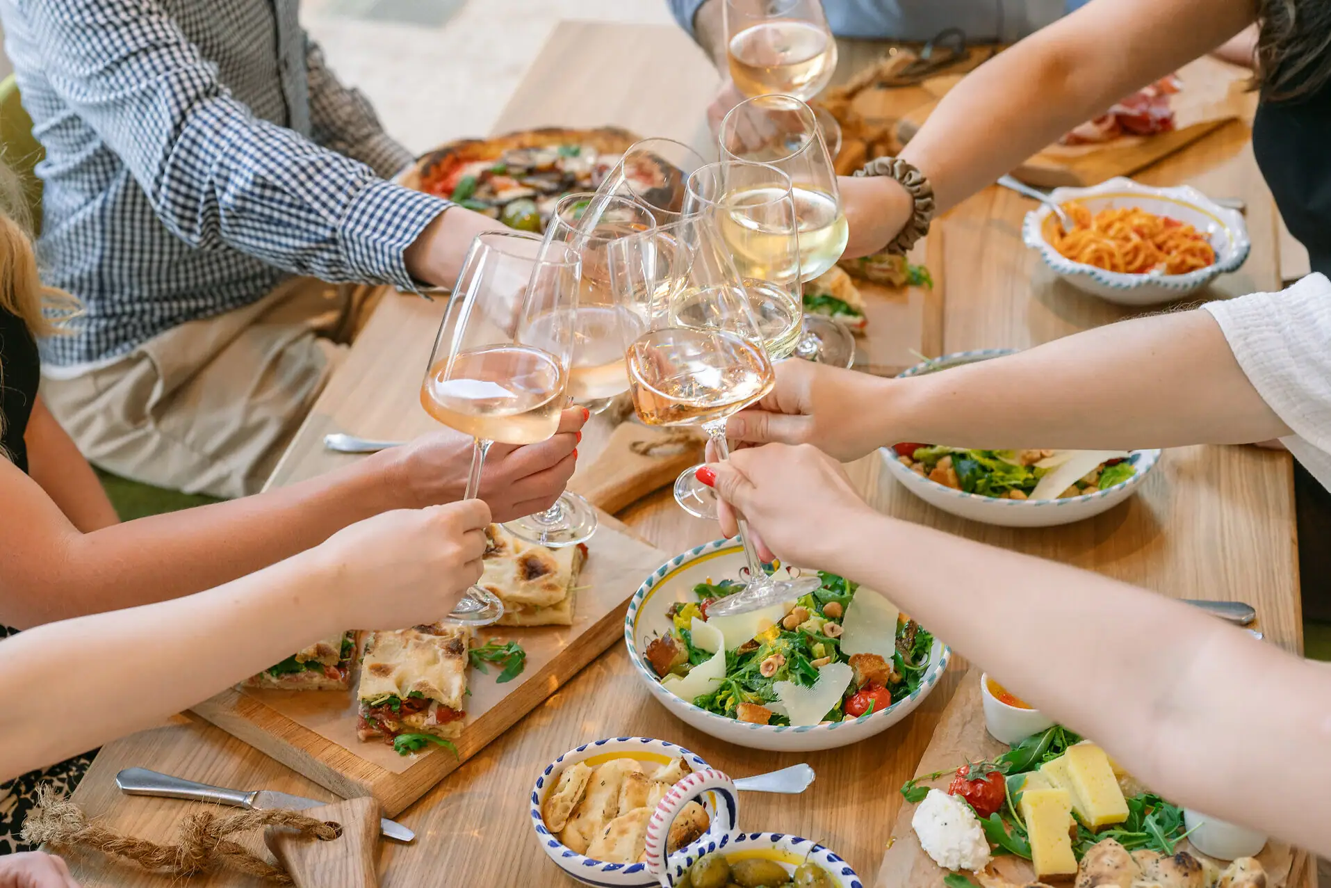 Anstoßen mit Wein Eine Gruppe von Menschen hält Weingläser.