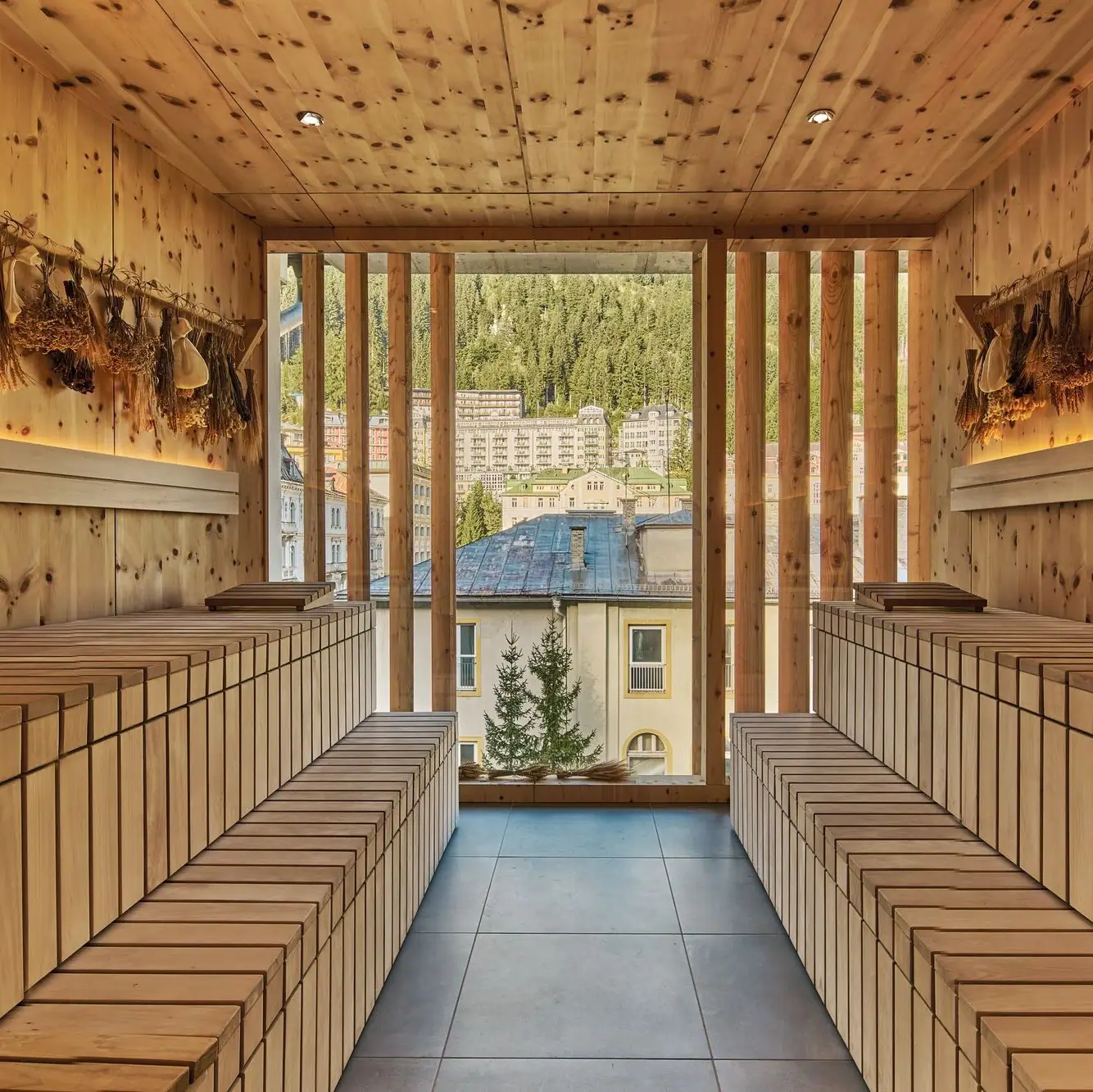 Ein Innenraum einer Sauna mit Holzbänken und einem Fenster.