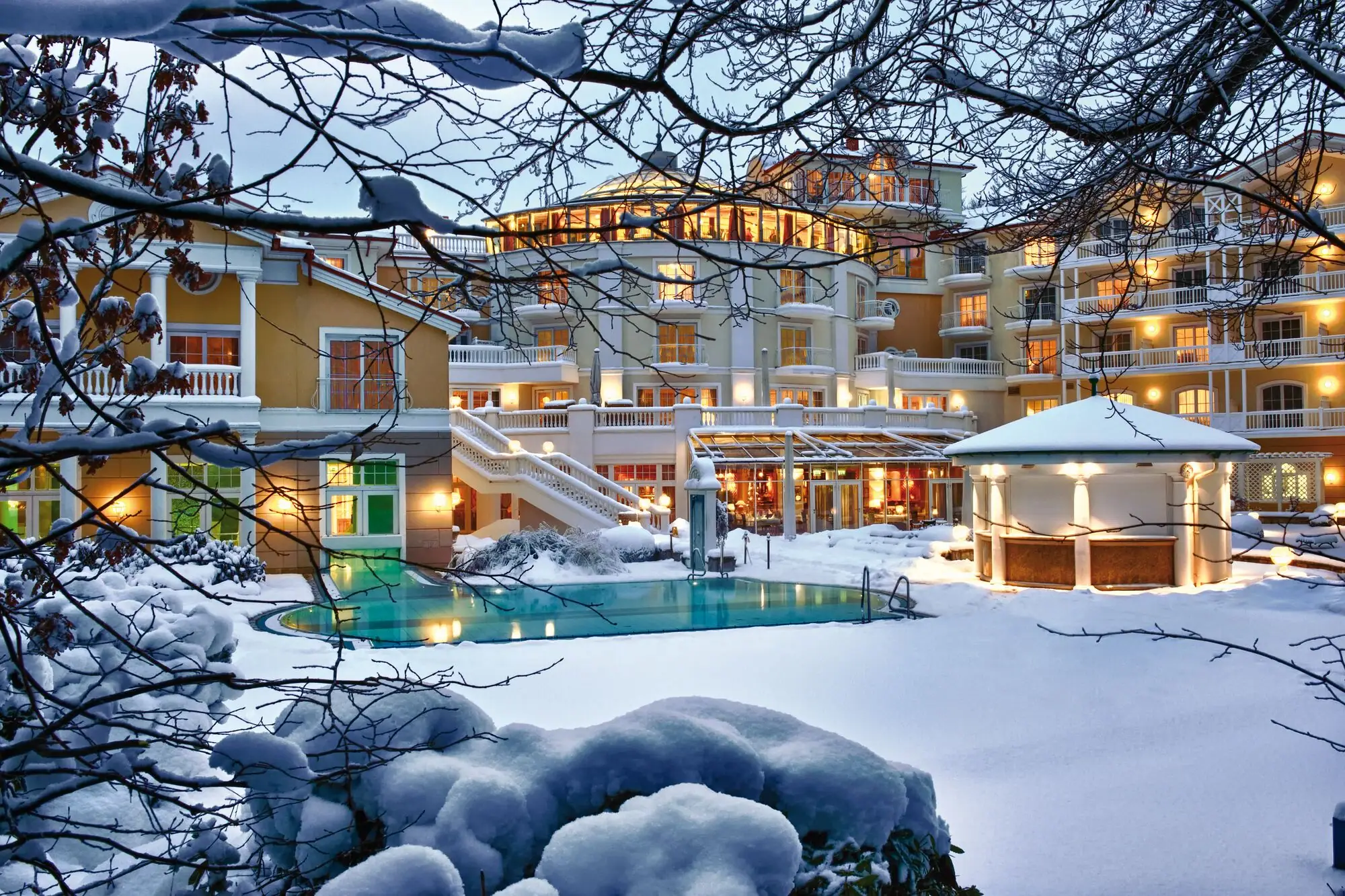Ein Gebäude mit einem Pool im Schnee, umgeben von winterlicher Landschaft.