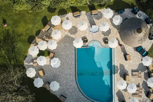 Luftaufnahme eines Pools mit Sonnenschirmen