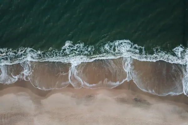 Küste Sylt Küstenlandschaft auf Sylt mit Wellen, die auf einen Strand treffen
