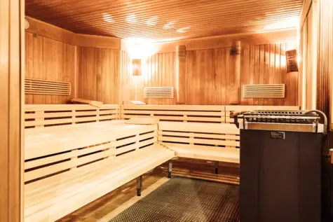 Eine Sauna mit Holzbänken und Beleuchtung.