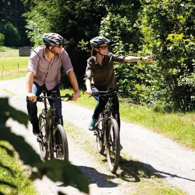 Ein Mann und eine Frau fahren auf einem Weg Fahrrad.