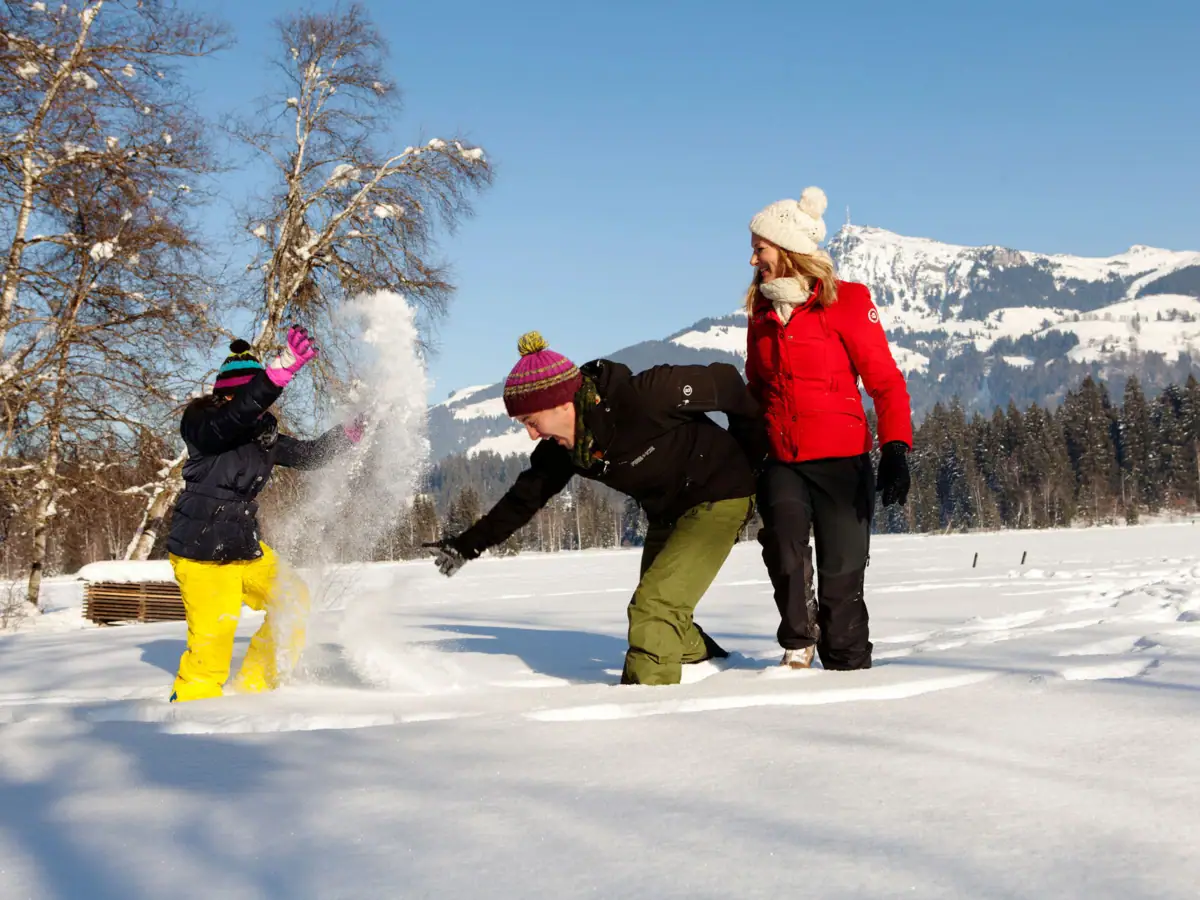 Eine Gruppe von Menschen spielt im Schnee.