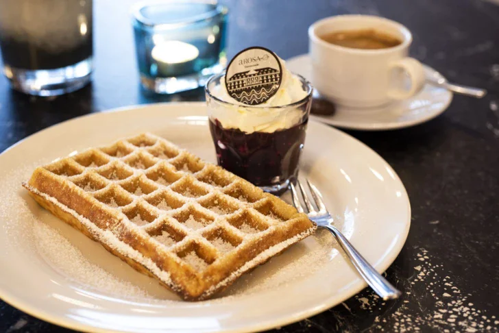 Waffle belga e tazza di caffè su un piatto.