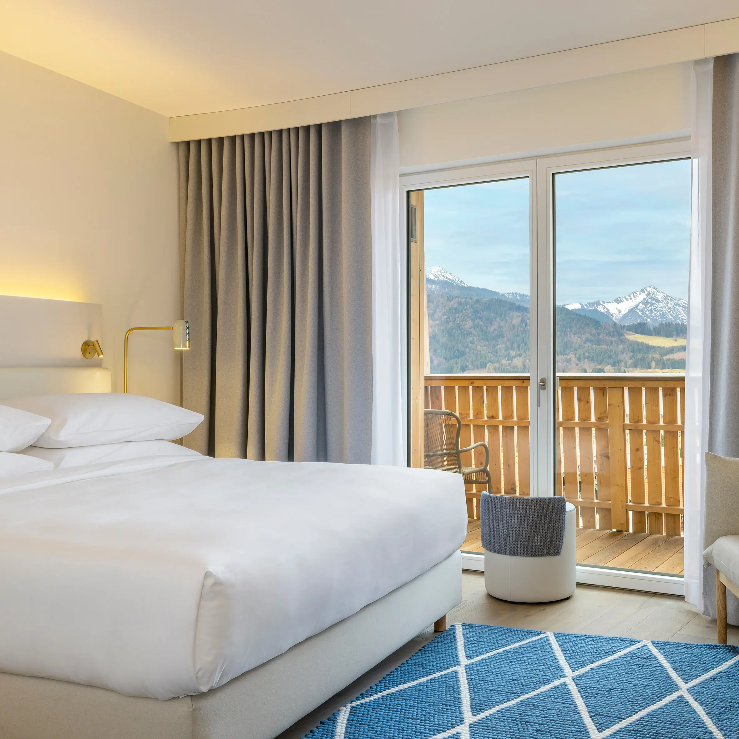 Zimmer & Suiten Ein Zimmer mit einem Bett, einem Teppich und einem Stuhl.