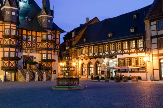 Gebäude mit einem Brunnen davor bei Nacht.