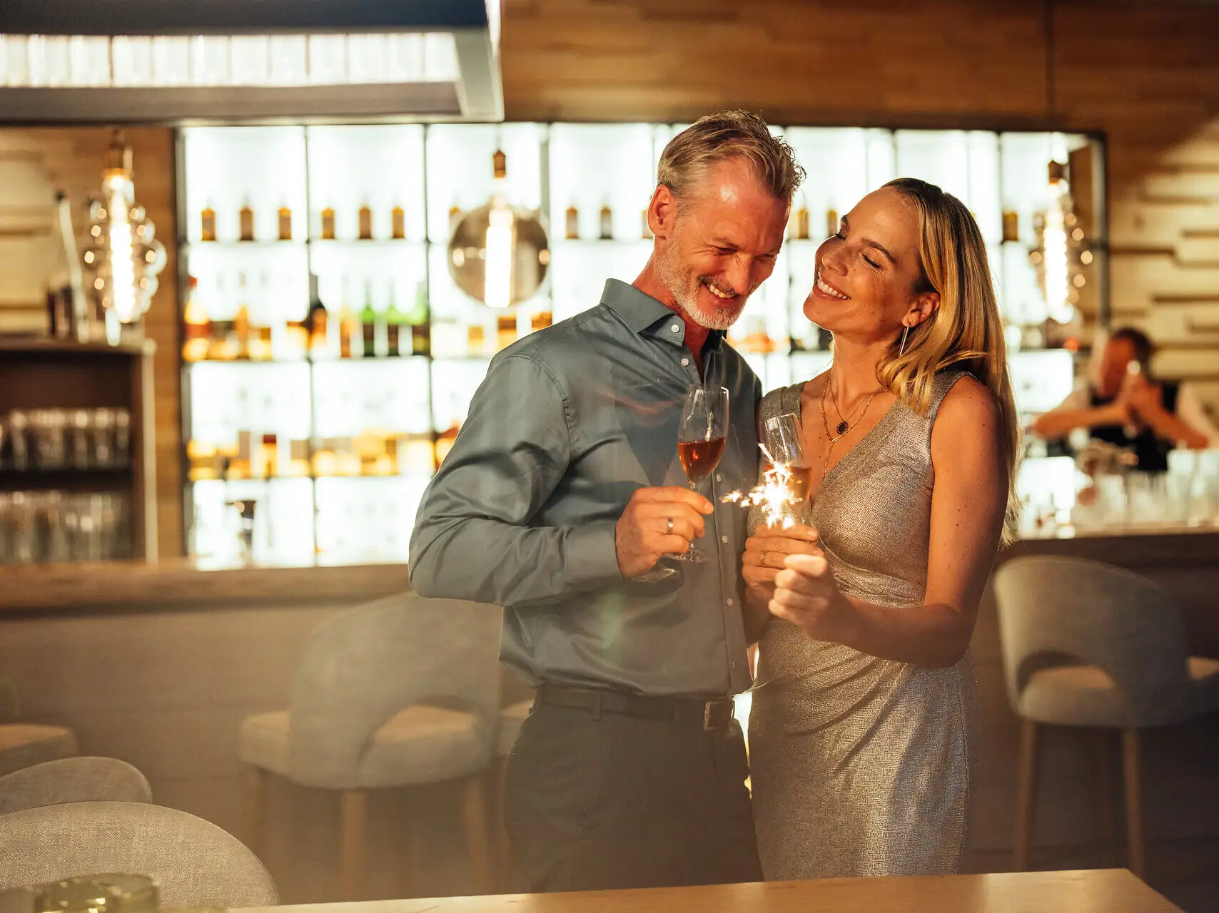 Ein Mann und eine Frau stoßen mit Champagnergläsern an.