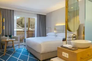 Schlafbereich mit offenem Bad Schlafzimmer mit großem Bett und Spiegel.