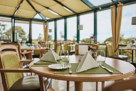 Elegante Tischdekoration in einem Restaurant, mit Geschirr und Tischdecke.