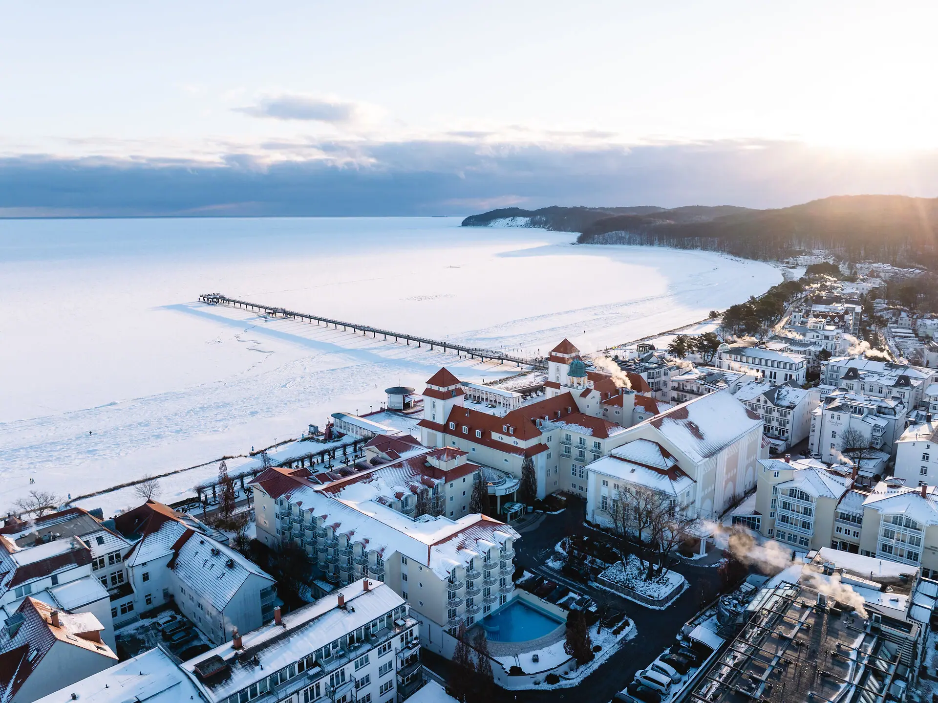 Eine schneebedeckte Stadt neben einem Gewässer.