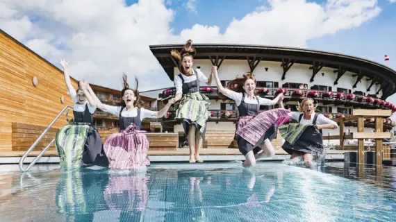 Gruppe von Frauen, die in einen Swimmingpool springen.