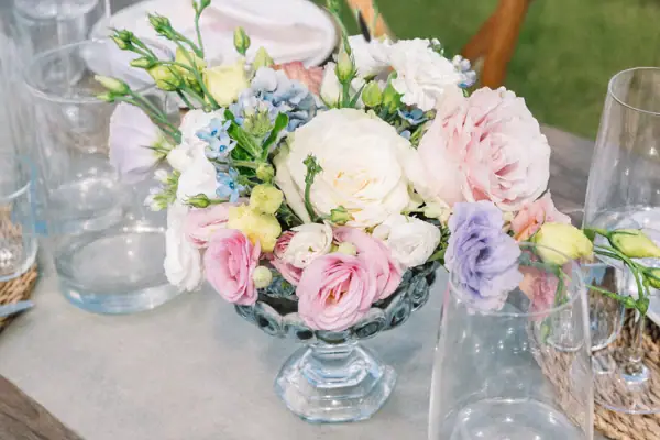 Romantisches Blumenarrangement in zarten Pastelltönen auf einem Hochzeitstisch.