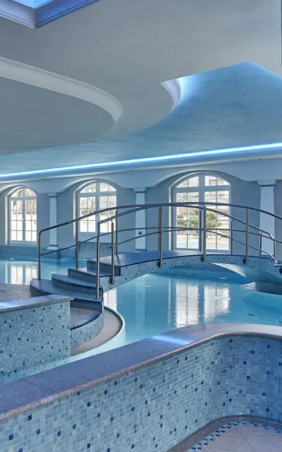 Innenpool mit Whirlpool und Treppe in einem stilvollen Raum.