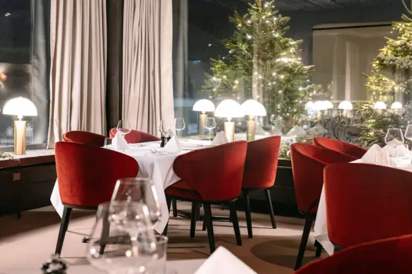 Ein Raum mit einem gedeckten Tisch und roten Stühlen..