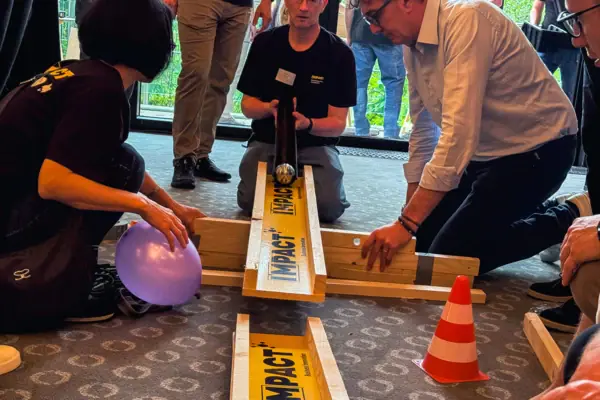 Kettenreaktion Eine Gruppe von Menschen spielt mit einer Murmelbahn