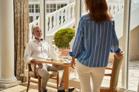 Frau und Mann stehen neben einem Tisch.