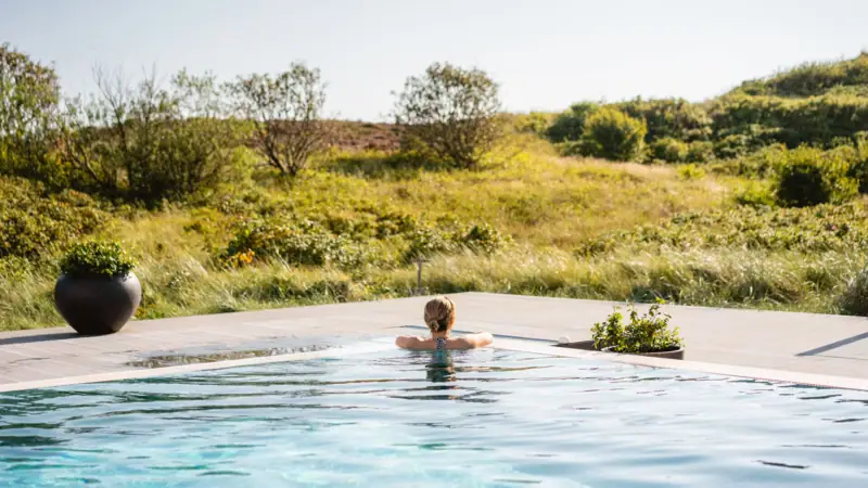 Eine Frau schwimmt in einem Pool im Freien.