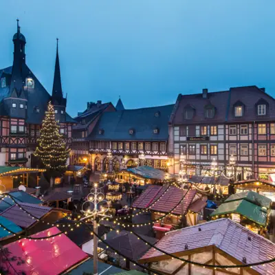 Ein Weihnachtsmarkt mit vielen Zelten und Lichtern im Freien.