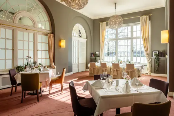 A-ROSA Veranstaltungsraum Hanse Zimmer Ein Raum mit Tischen und Stühlen im A-ROSA Travemünde.