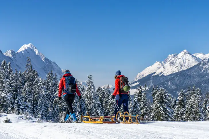 Eine Gruppe von Menschen wandert auf einem verschneiten Berg.