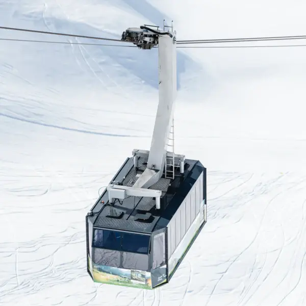 Eine Gondel über verschneiter Landschaft in einem Skigebiet.