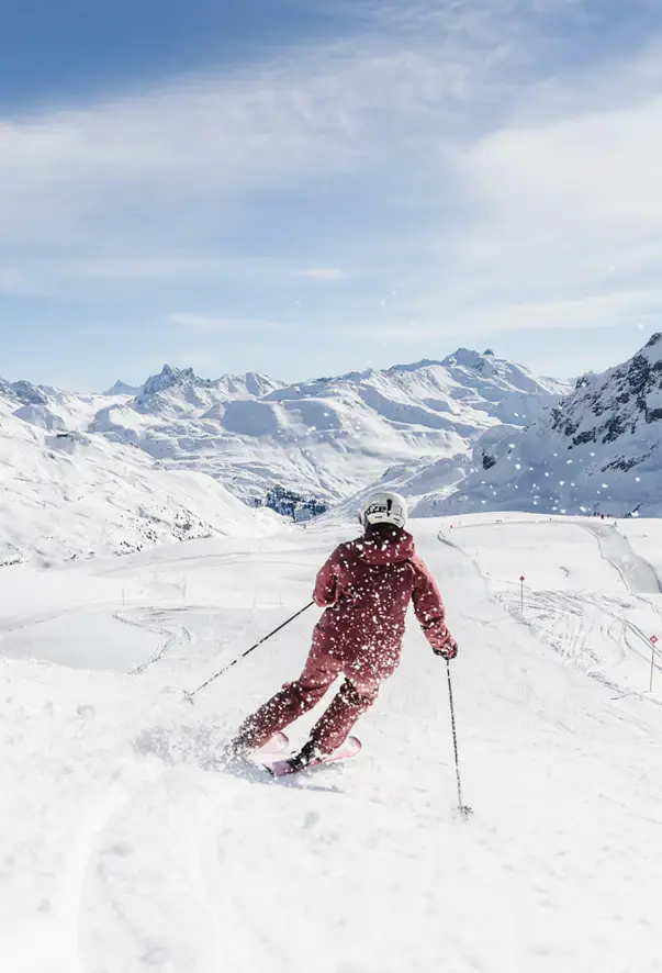 Person beim Skifahren auf einem verschneiten Berghang.