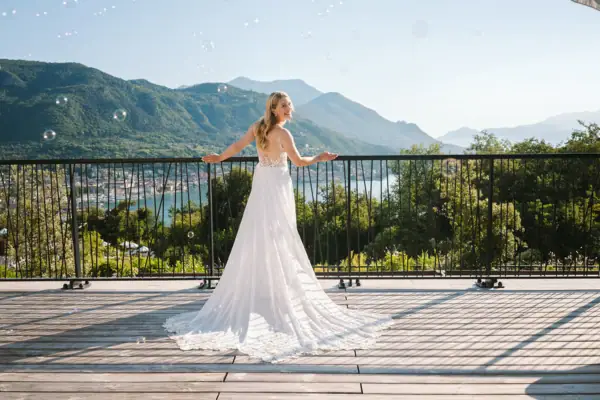 Braut im Hochzeitskleid auf der Terrasse der A-ROSA Suite mit Blick über den Gardasee.