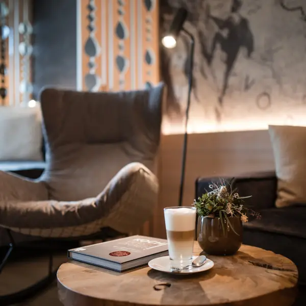 Ein Sofa mit Kissen und ein Tisch mit Lampen in einem Innenraum.