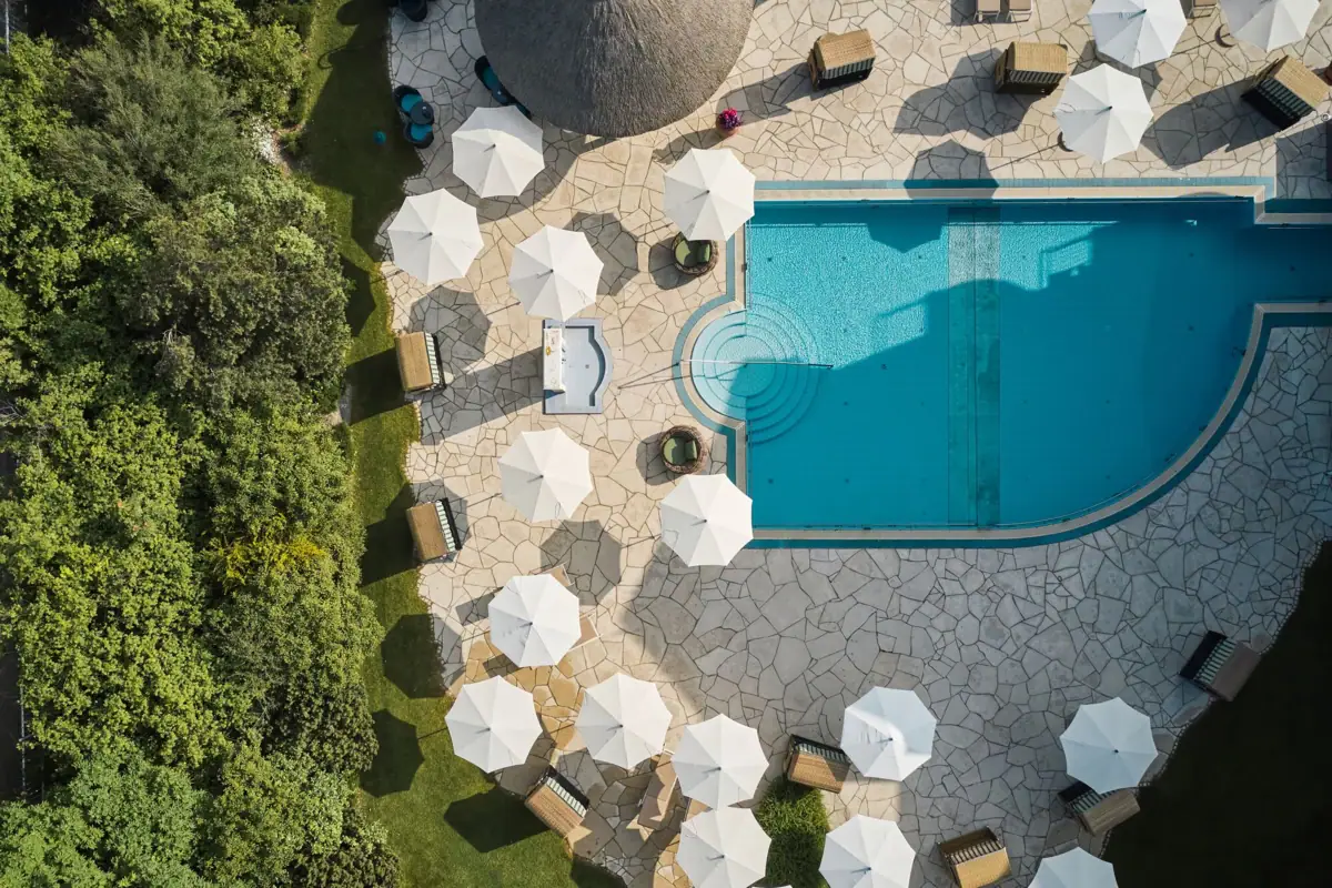 Ein Außenpool mit Sonnenschirmen und Liegestühlen.