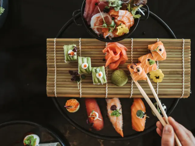 Buntes Sushi mit Bambusmatte und Stäbchen als mögliches Hochzeitsessen